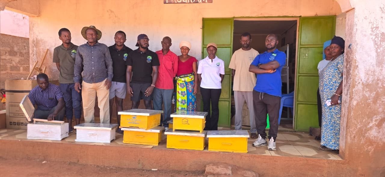 Eco-Jipe staff and community beekeepers standing with new hives outside the Eco-Jipe office